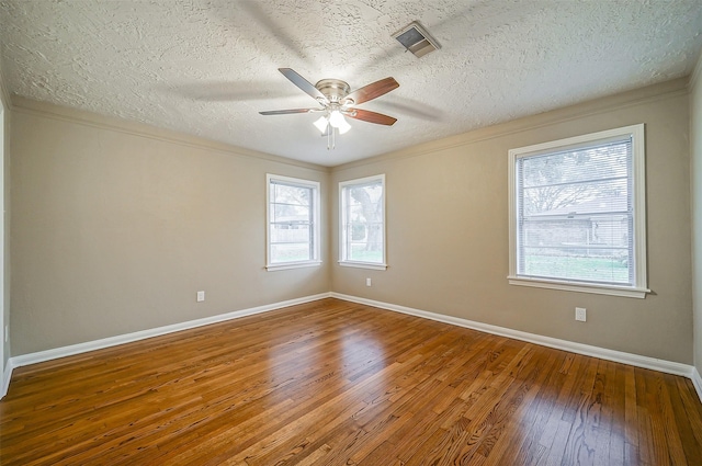 unfurnished room with hardwood / wood-style floors, a textured ceiling, ceiling fan, and ornamental molding