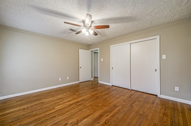 unfurnished bedroom with ceiling fan, wood-type flooring, crown molding, and a textured ceiling