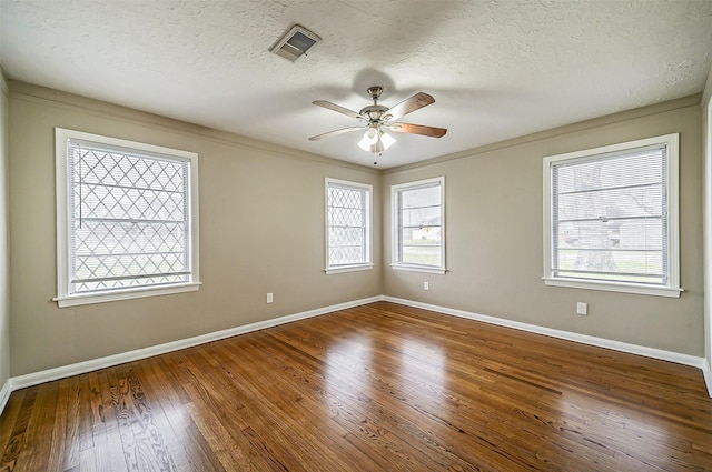 empty room featuring ceiling fan, hardwood / wood-style floors, ornamental molding, and a textured ceiling