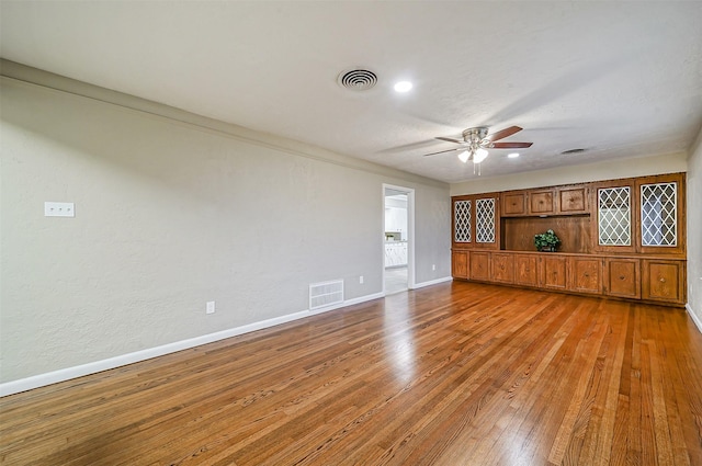 spare room with hardwood / wood-style flooring, ceiling fan, and ornamental molding