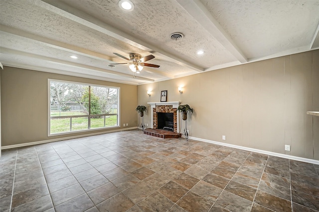 unfurnished living room featuring a brick fireplace, ceiling fan, a textured ceiling, and beamed ceiling