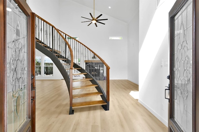 foyer entrance featuring ceiling fan, high vaulted ceiling, french doors, and light hardwood / wood-style floors