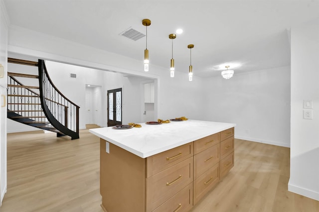 kitchen featuring light brown cabinets, pendant lighting, french doors, a kitchen island, and light hardwood / wood-style floors