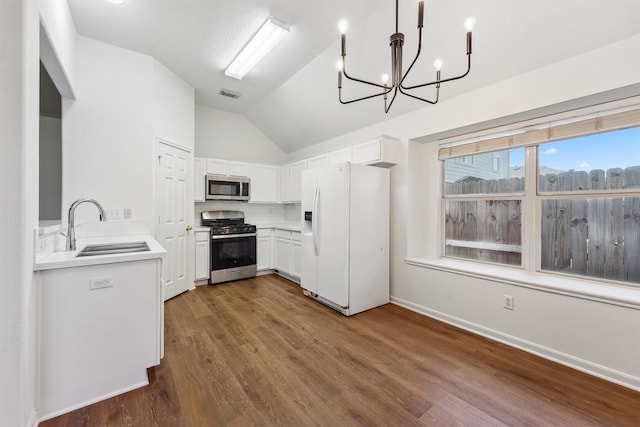 kitchen with hanging light fixtures, sink, backsplash, white cabinets, and stainless steel appliances