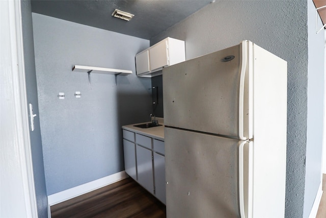 kitchen with sink, white refrigerator, white cabinets, and dark hardwood / wood-style floors