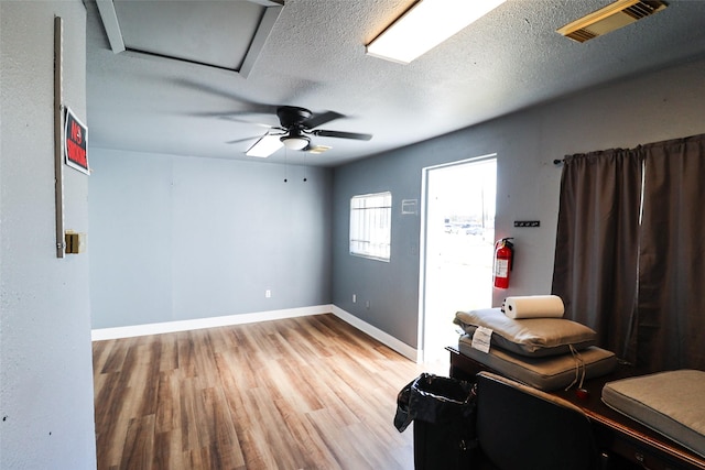 interior space with wood-type flooring, a textured ceiling, and ceiling fan