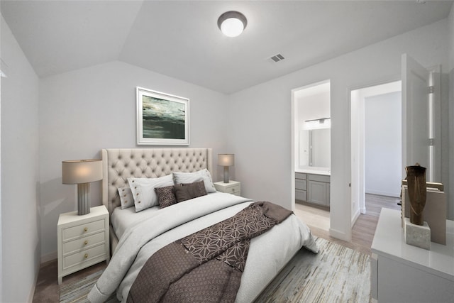 bedroom featuring lofted ceiling and ensuite bathroom