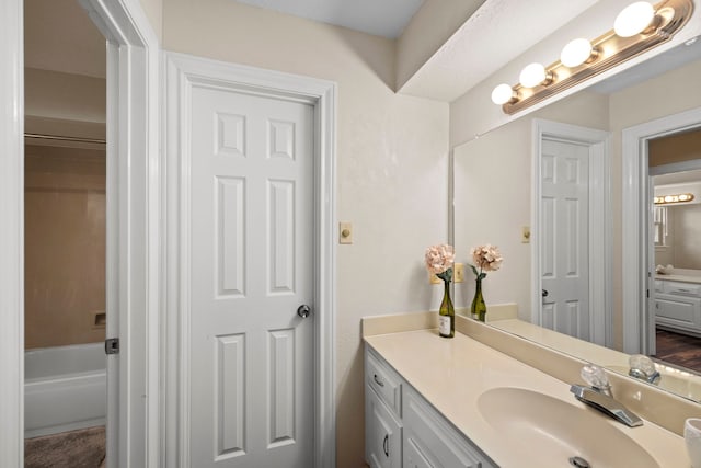 bathroom with vanity and a washtub