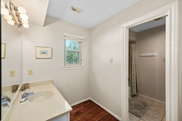 bathroom featuring an inviting chandelier, vanity, and wood-type flooring