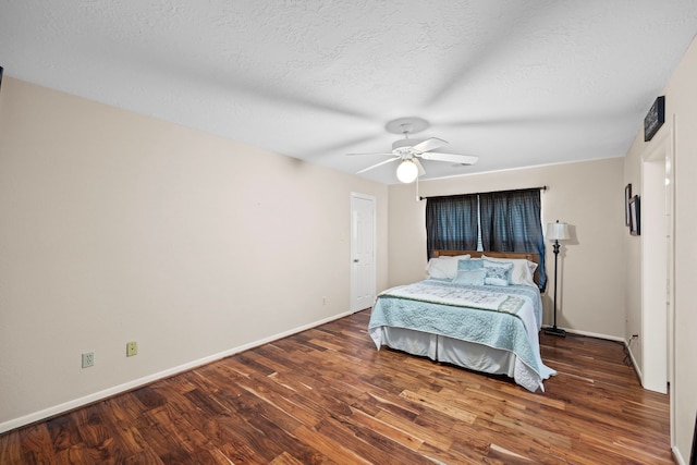 bedroom with ceiling fan, dark wood-type flooring, and a textured ceiling