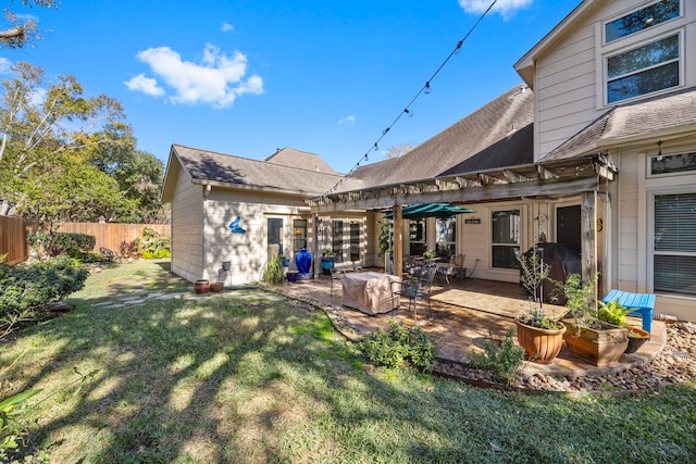 back of property featuring a pergola, a patio area, and a lawn