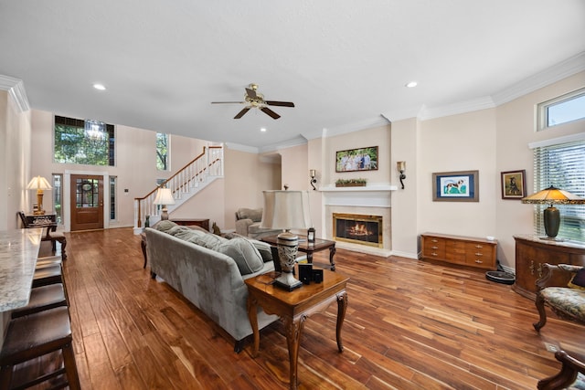 living room with hardwood / wood-style floors, crown molding, and ceiling fan