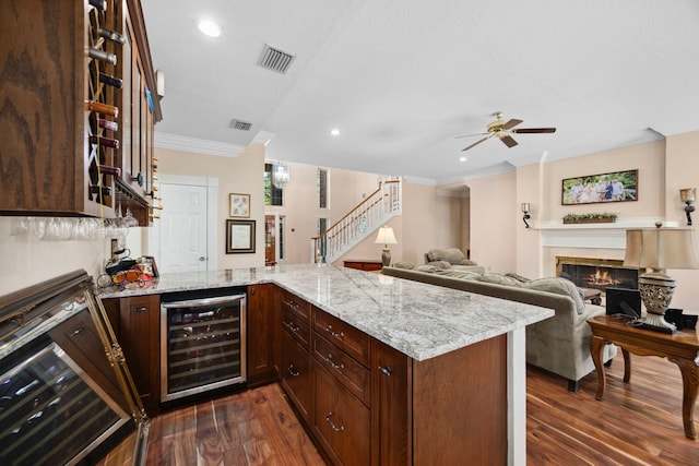 kitchen featuring light stone countertops, beverage cooler, and kitchen peninsula