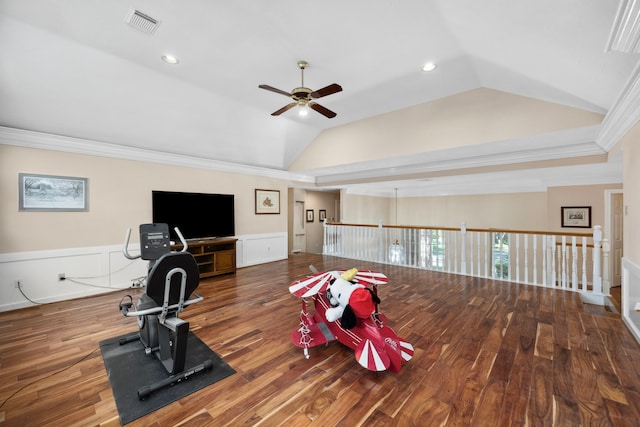 exercise room with vaulted ceiling, dark hardwood / wood-style flooring, ornamental molding, and ceiling fan