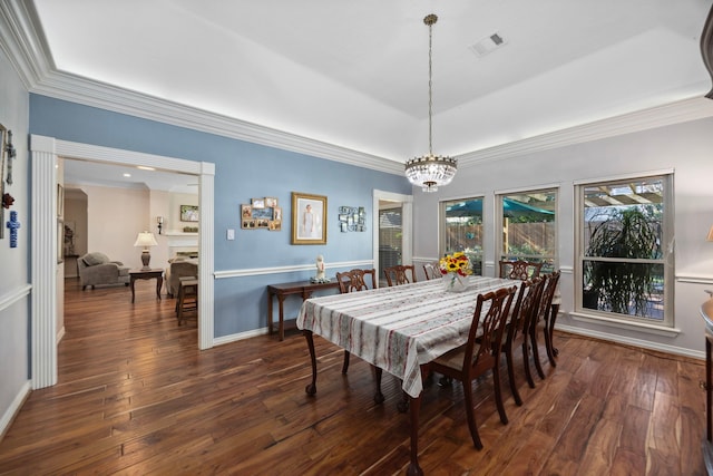 dining area with crown molding, dark wood-type flooring, and a chandelier