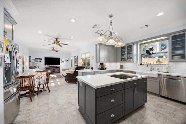 kitchen with stainless steel appliances, sink, a kitchen island, and gray cabinetry