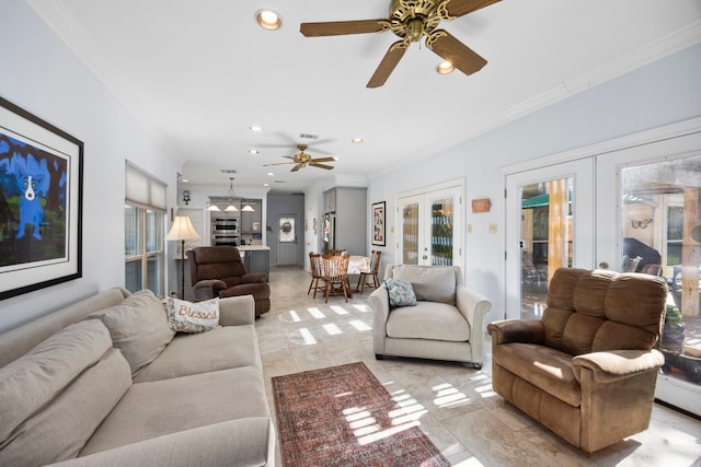 living room featuring a wealth of natural light, ornamental molding, french doors, and ceiling fan