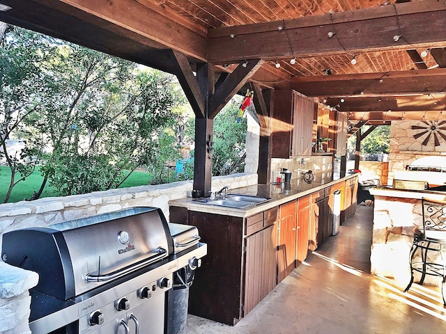 view of patio with sink, grilling area, an outdoor stone fireplace, and area for grilling