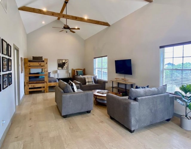 living room featuring high vaulted ceiling, beamed ceiling, and light hardwood / wood-style floors