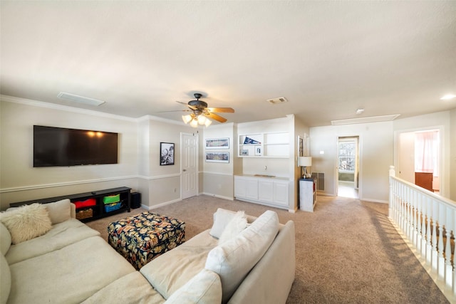 carpeted living room featuring ornamental molding and ceiling fan