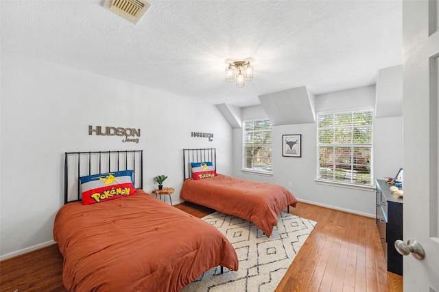 bedroom featuring hardwood / wood-style floors and a textured ceiling