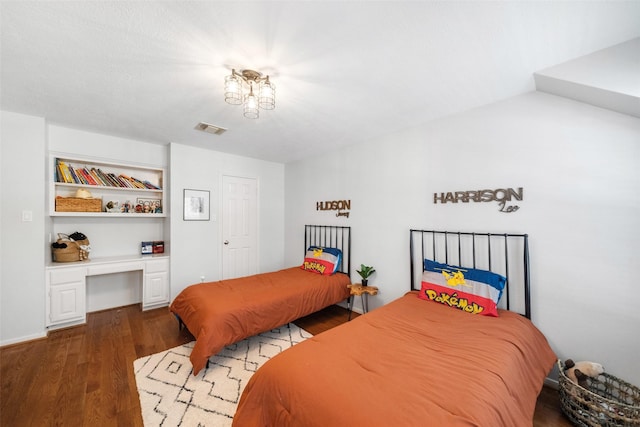 bedroom featuring built in desk and wood-type flooring