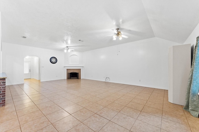 unfurnished living room featuring vaulted ceiling, light tile patterned floors, and ceiling fan