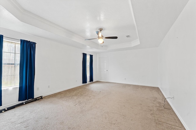 carpeted empty room featuring ceiling fan and a tray ceiling