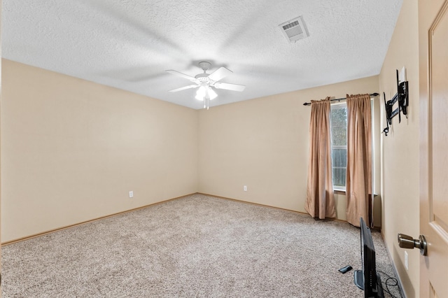 carpeted spare room with a textured ceiling and ceiling fan