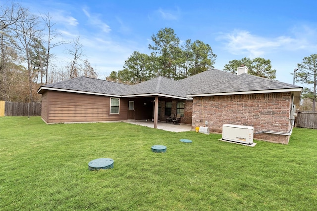 back of property with a lawn and a patio area