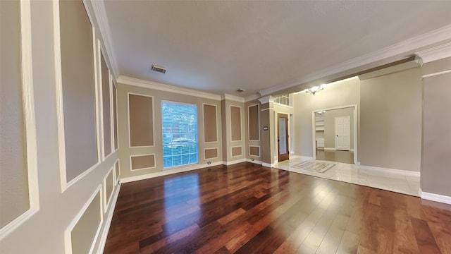 empty room with hardwood / wood-style flooring and crown molding