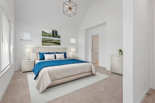 bedroom with light colored carpet, a chandelier, and high vaulted ceiling