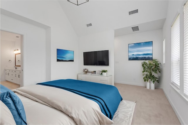 bedroom with vaulted ceiling, connected bathroom, light carpet, and multiple windows