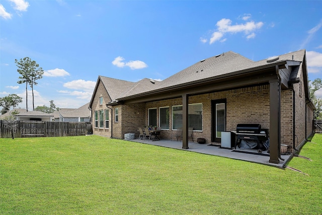 rear view of property featuring a patio area and a lawn