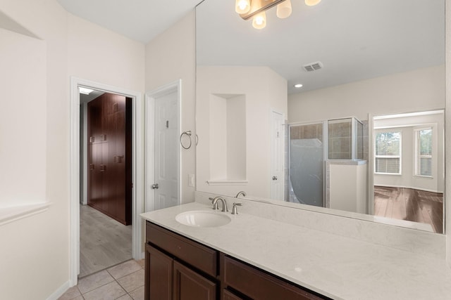 bathroom with tile patterned floors, walk in shower, and vanity