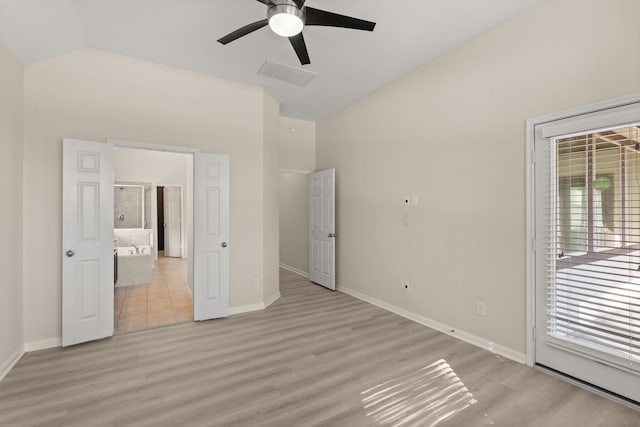 unfurnished bedroom featuring ceiling fan, multiple windows, light hardwood / wood-style flooring, and vaulted ceiling