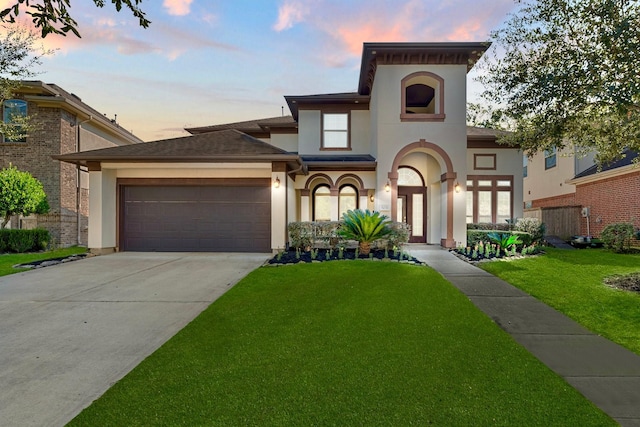 view of front of house with a garage and a lawn