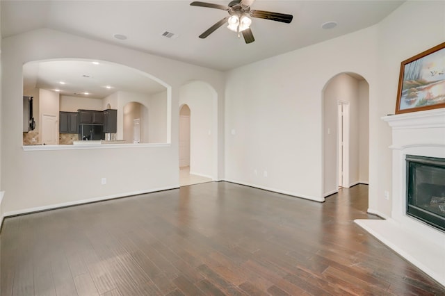 unfurnished living room with dark hardwood / wood-style floors and ceiling fan