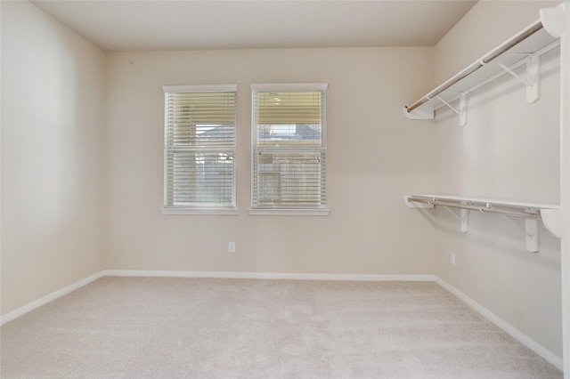 walk in closet featuring light carpet