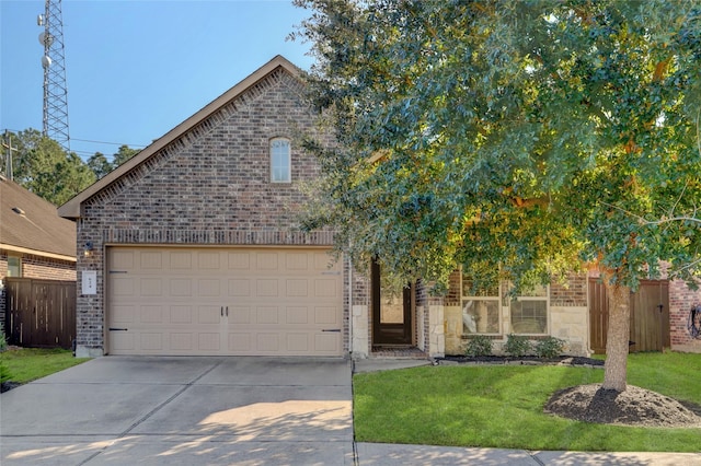 view of front of house with a front yard, concrete driveway, brick siding, and fence