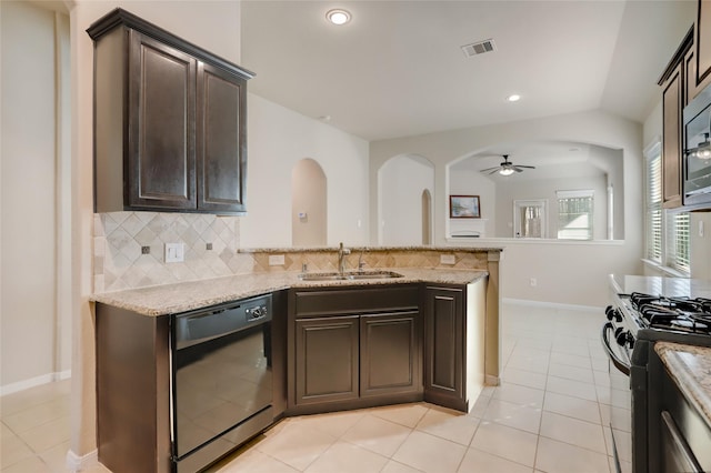 kitchen featuring dark brown cabinetry, black appliances, lofted ceiling, sink, and backsplash