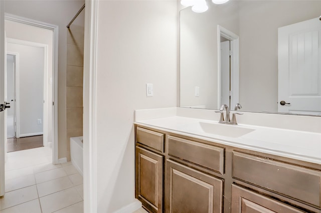 bathroom with tiled shower / bath combo, tile patterned flooring, and vanity