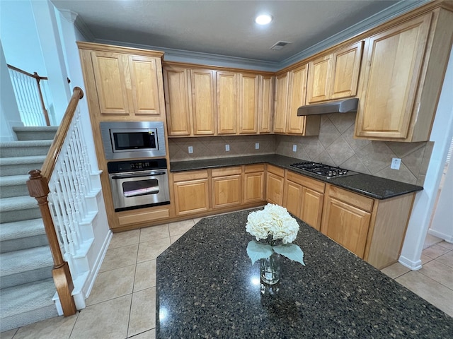 6731 Pinetop Glen Ln, Spring, TX 77379 - kitchen with appliances with stainless steel finishes, under cabinet range hood, tasteful backsplash, dark stone countertops, and light tile patterned floors