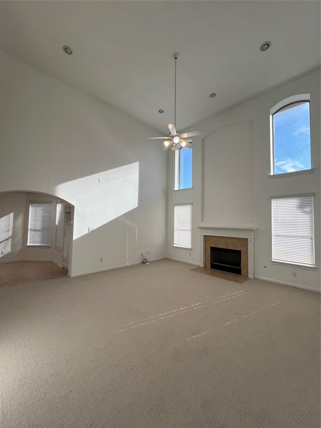 6731 Pinetop Glen Ln, Spring, TX 77379 - unfurnished living room featuring a high ceiling, a tile fireplace, carpet floors, ceiling fan, and recessed lighting