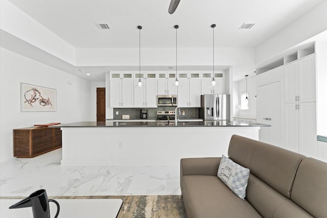 kitchen featuring appliances with stainless steel finishes, tasteful backsplash, white cabinetry, sink, and pendant lighting