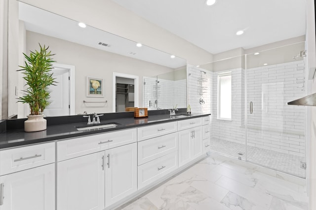 bathroom featuring vanity and a shower with door