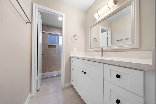 bathroom with tiled shower and vanity