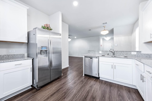 kitchen featuring sink, appliances with stainless steel finishes, dark hardwood / wood-style flooring, light stone countertops, and white cabinets