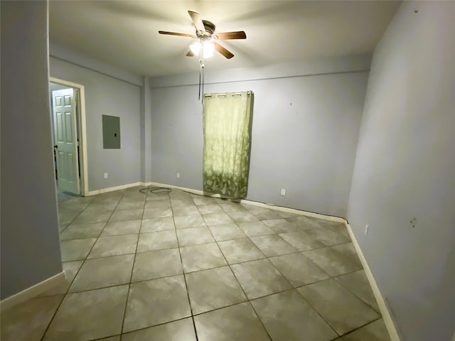 empty room featuring electric panel, light tile patterned floors, and ceiling fan