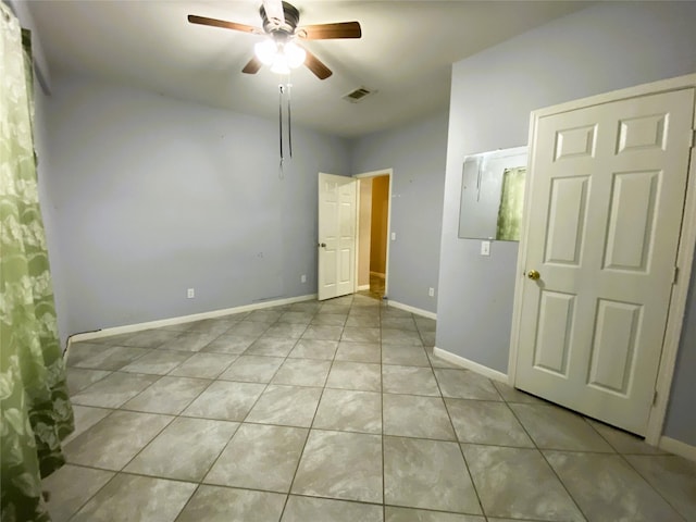 unfurnished room with ceiling fan and light tile patterned floors